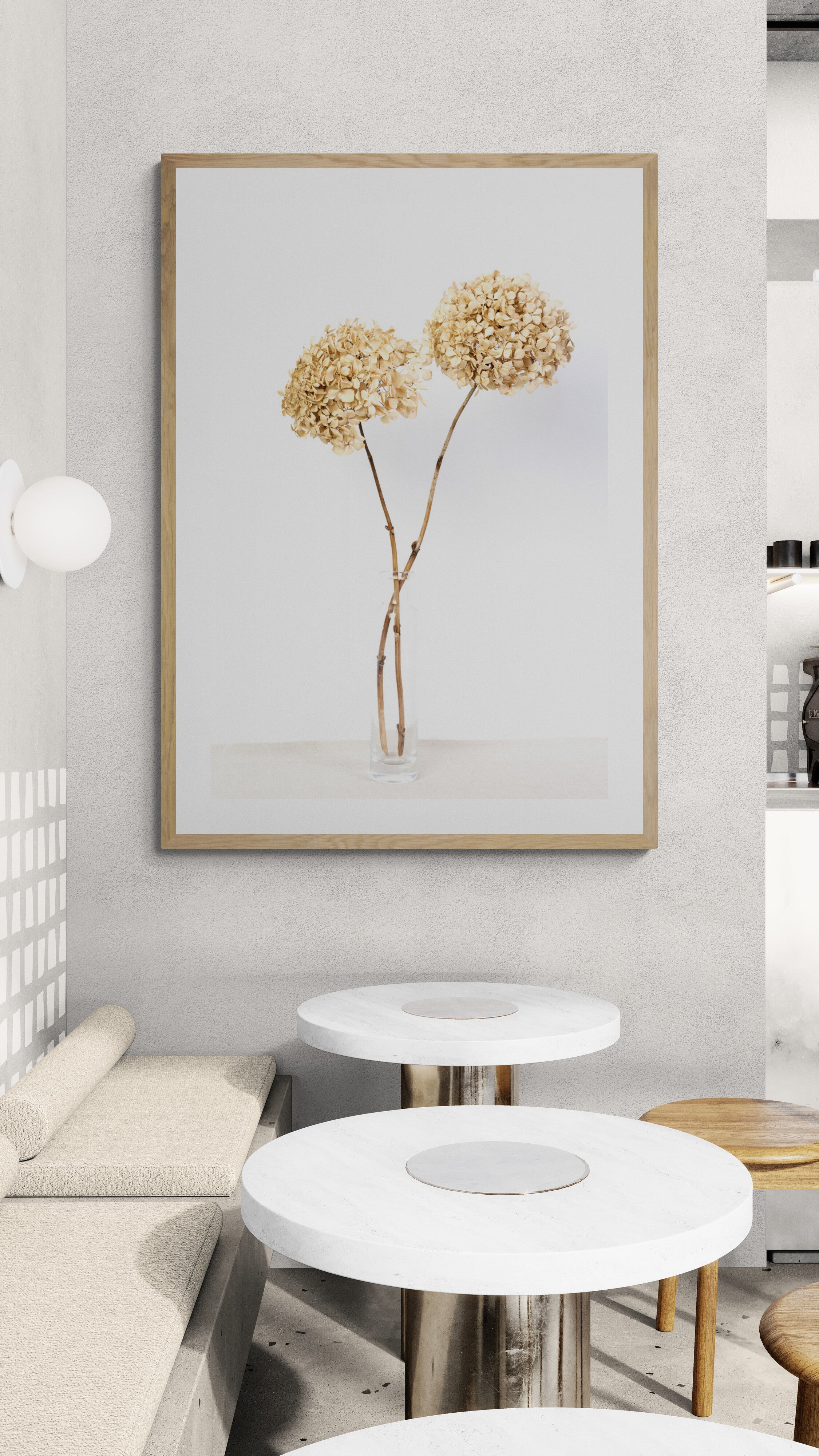 Framed artwork of dried flowers on a wall above a modern living room setup.